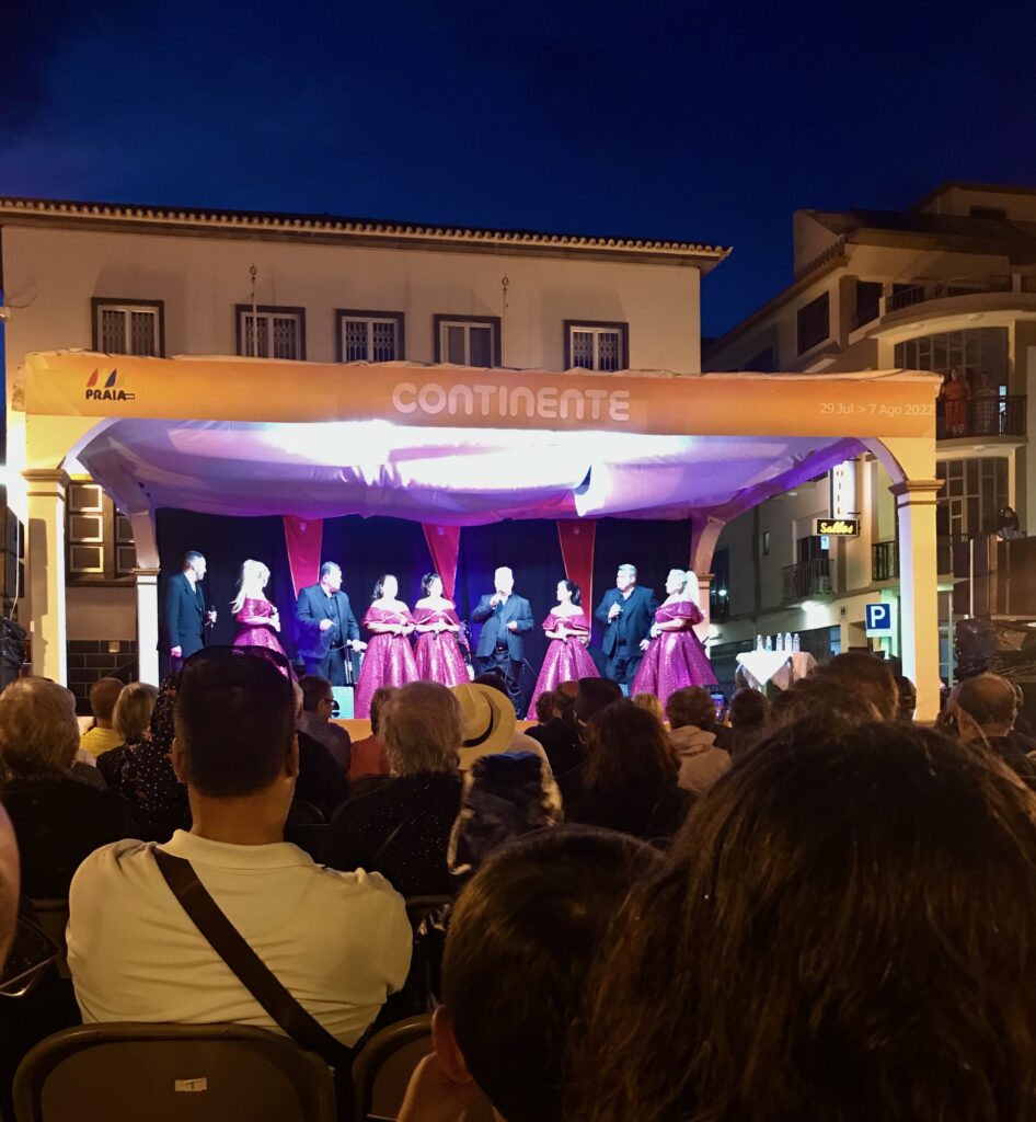 Men and Woman singing on stage at night festival in city square of Praia da Vitoria