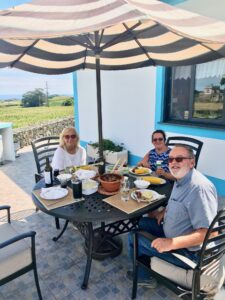 Friends and wife enjoying a great lunch on the Veranda with a sunny day, cool breeze blowing.