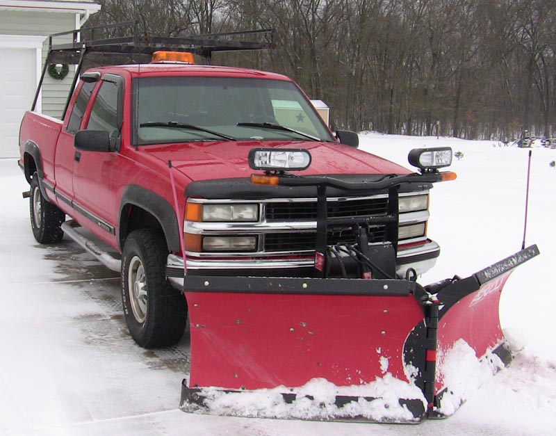 My truck and plow outside my snow-covered driveway in snowy Michigan, years before I retired to the Azores.