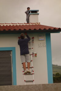 Two men painting Casa do Sonhos even in cloudy weather - experts make the work fast and excellent