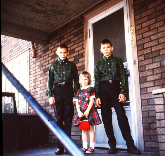 Rick, Rob, and little girl on the  front porch in Lansing heading out to school at Walnut Street Elementary.