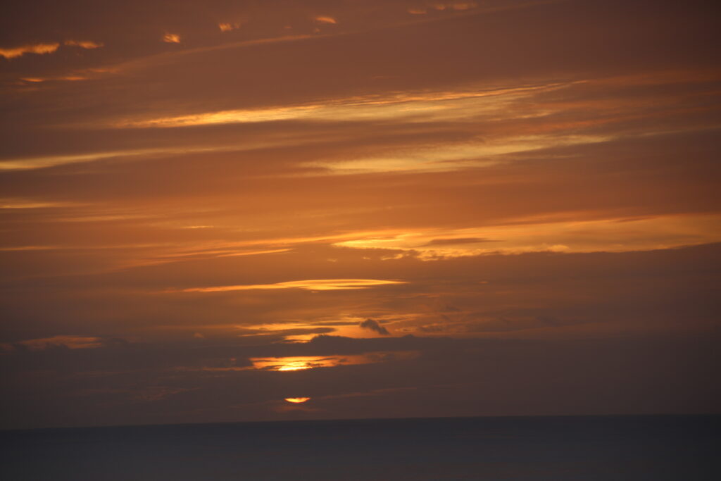 Colorful sky with sun behind clouds